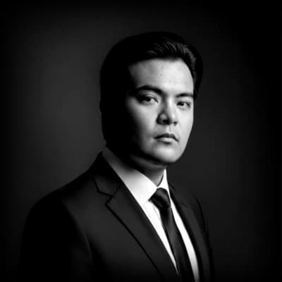 Black and white studio portrait of Carlos Anaya Ruiz, facing the camera against a dark background